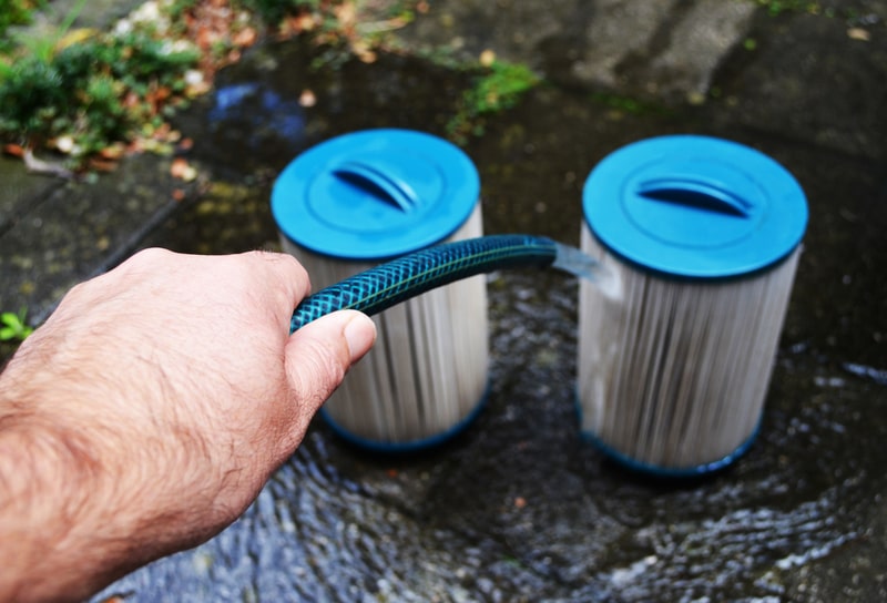 Hand cleaning hot tub filters with a hose pipe
